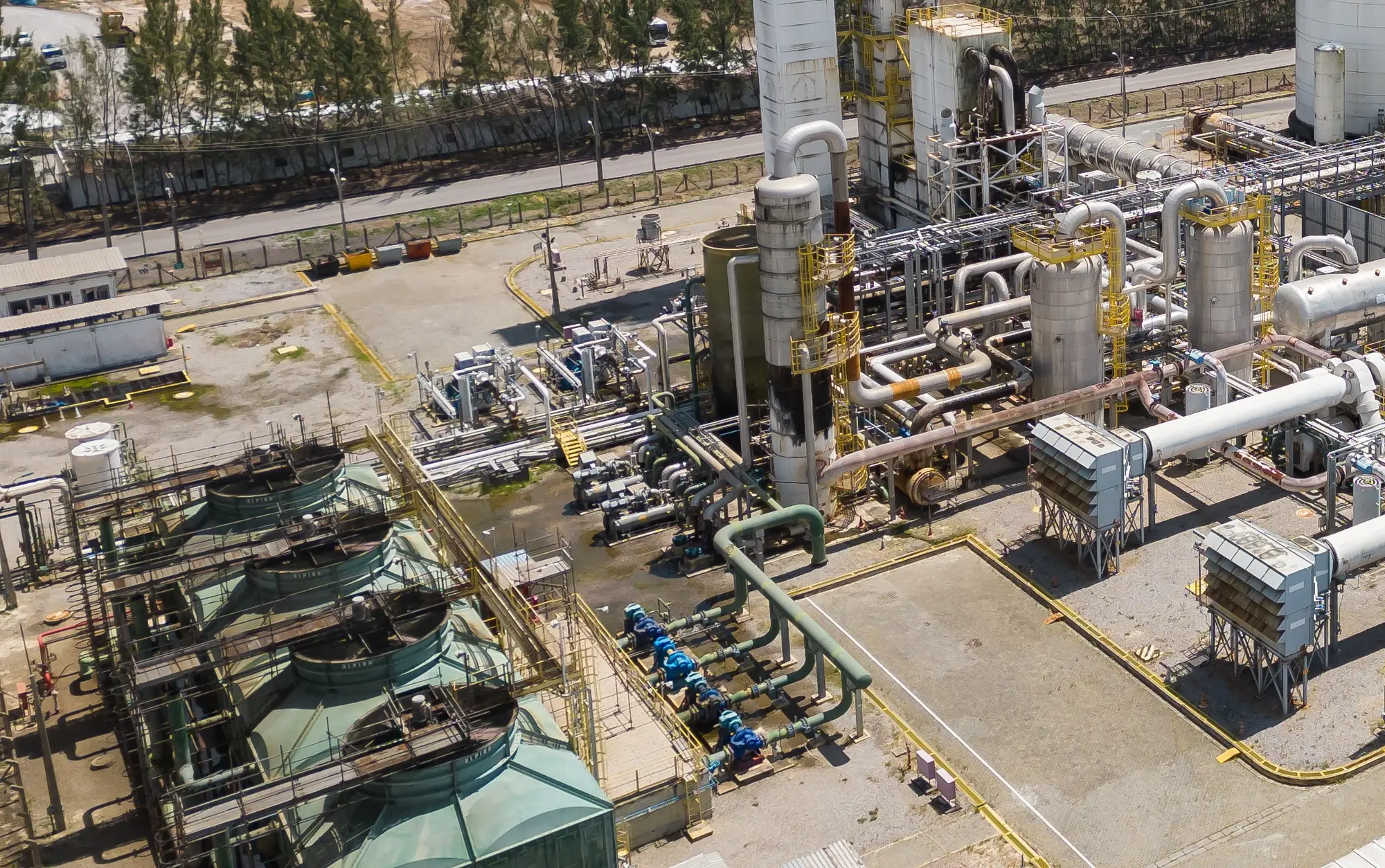 Tubulações, torres de resfriamento e equipamentos de uma planta de gases industriais vistos do alto